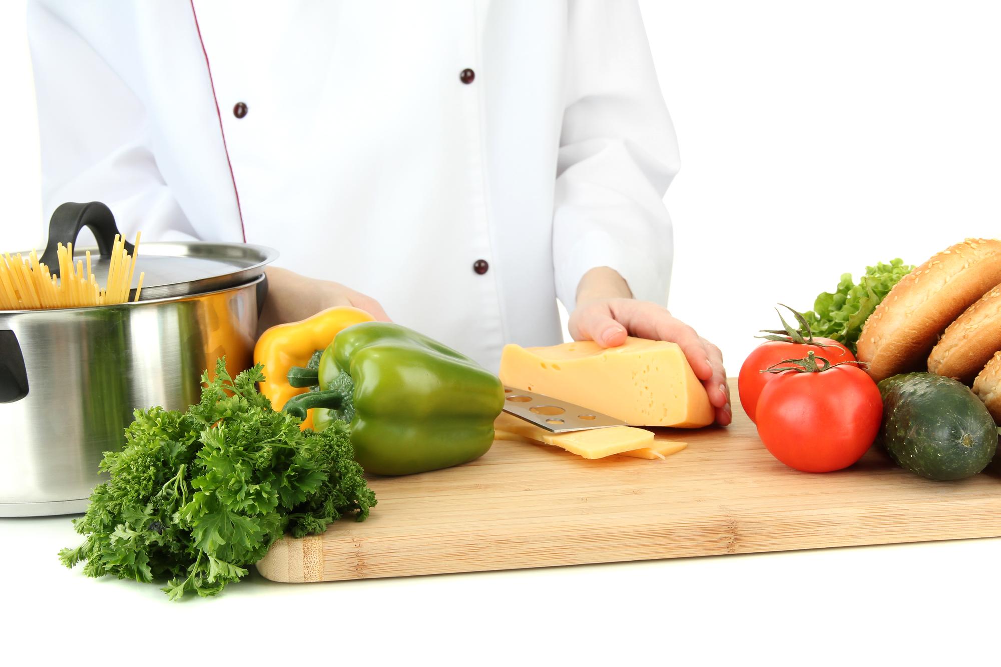 Student chopping vegetables in modern kitchen